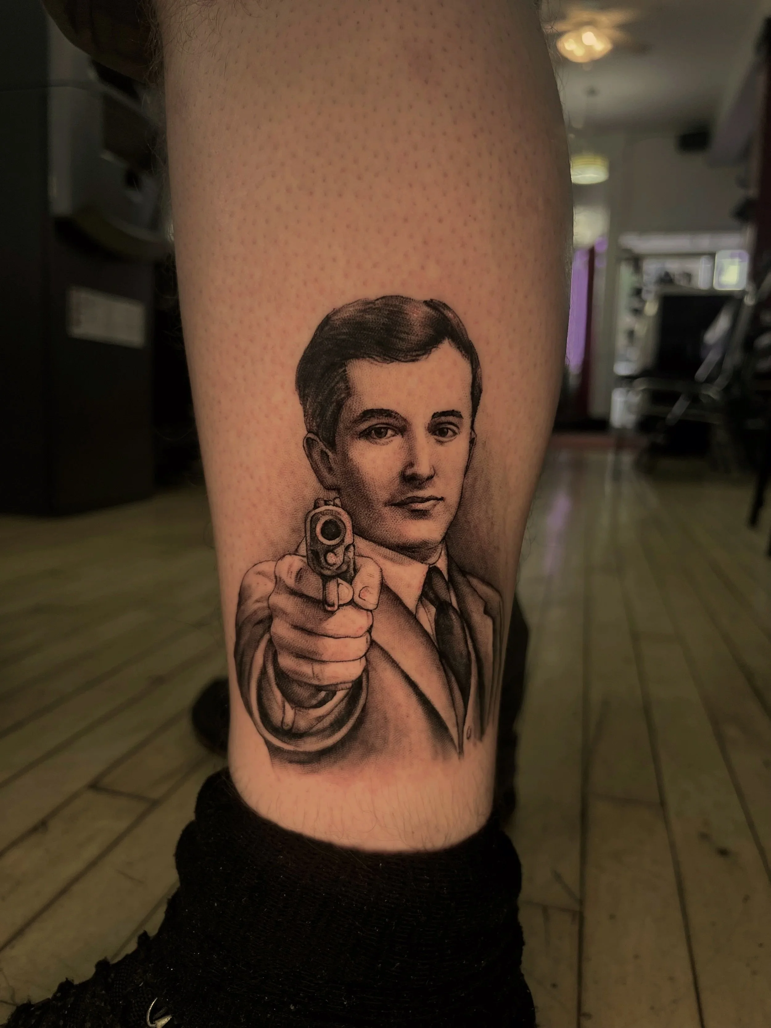 Tattoo of a woman holding a gun on a person's arm