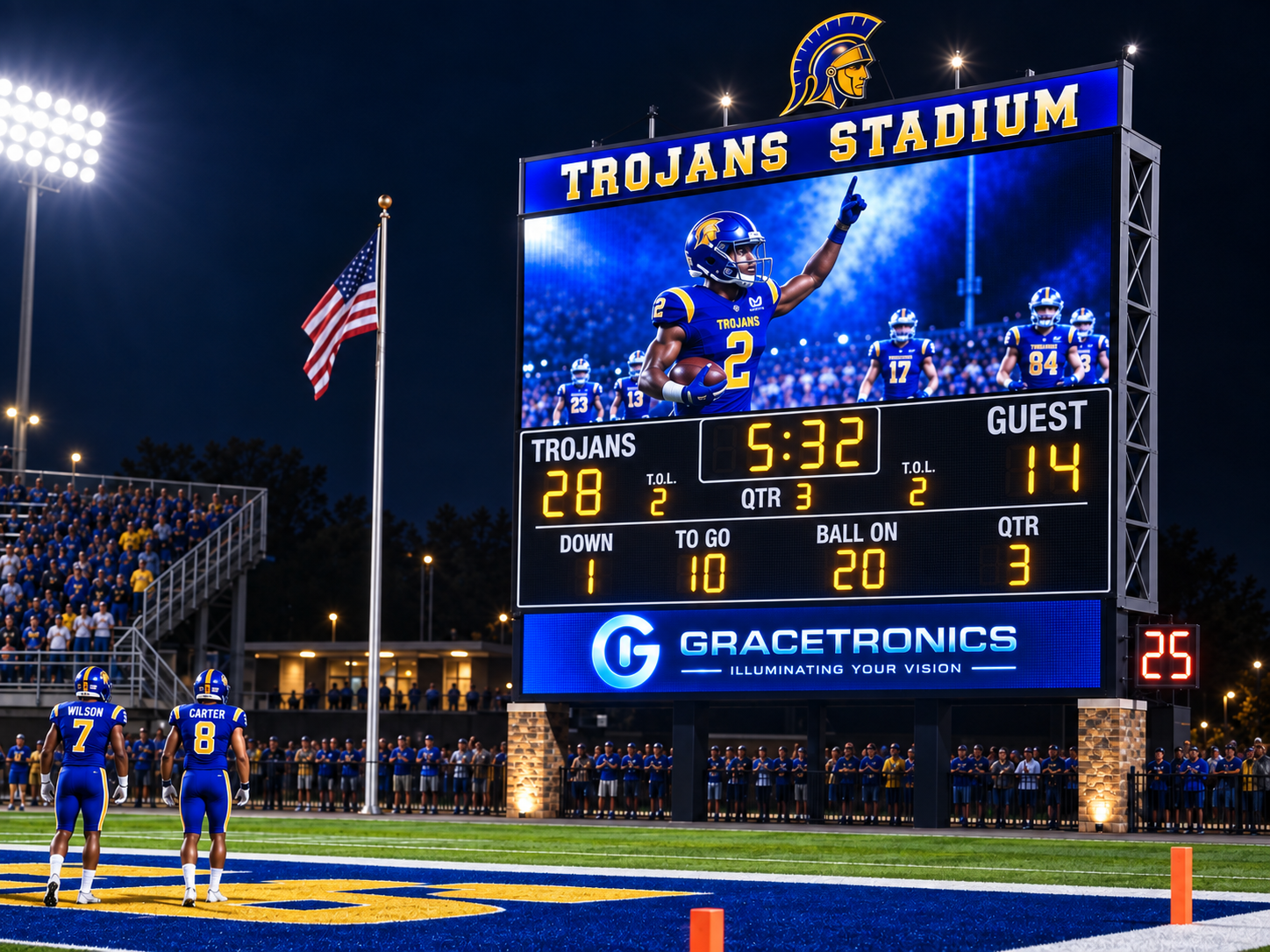 LED Scoreboard of a Football game at Trojans Stadium with players on the field, a digital scoreboard showing Trojans leading 28-14 in the third quarter, and a crowd in the stands at night.