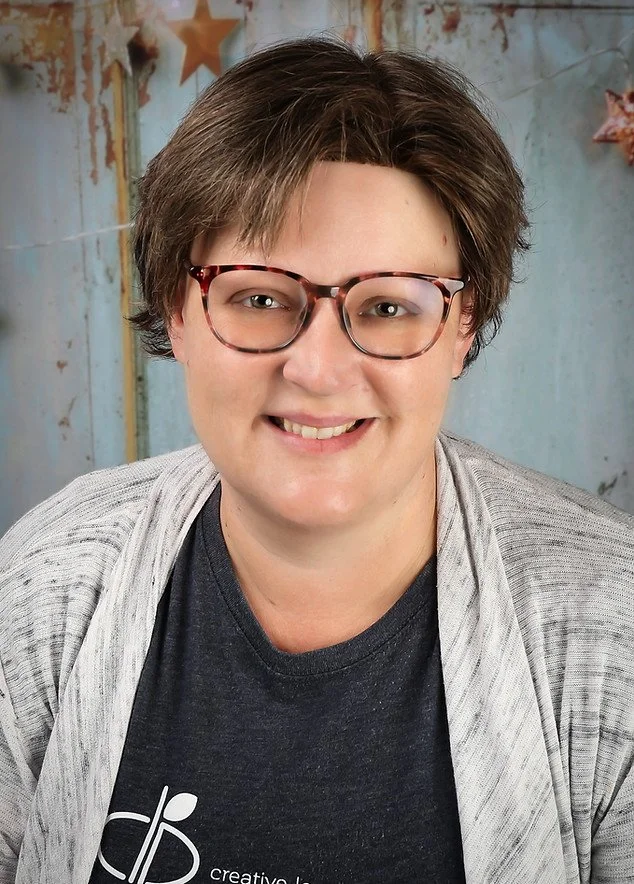Christina McGhygy, the training coordinator for the the Colorado Children's Alliance, is a woman with short brown hair and glasses.