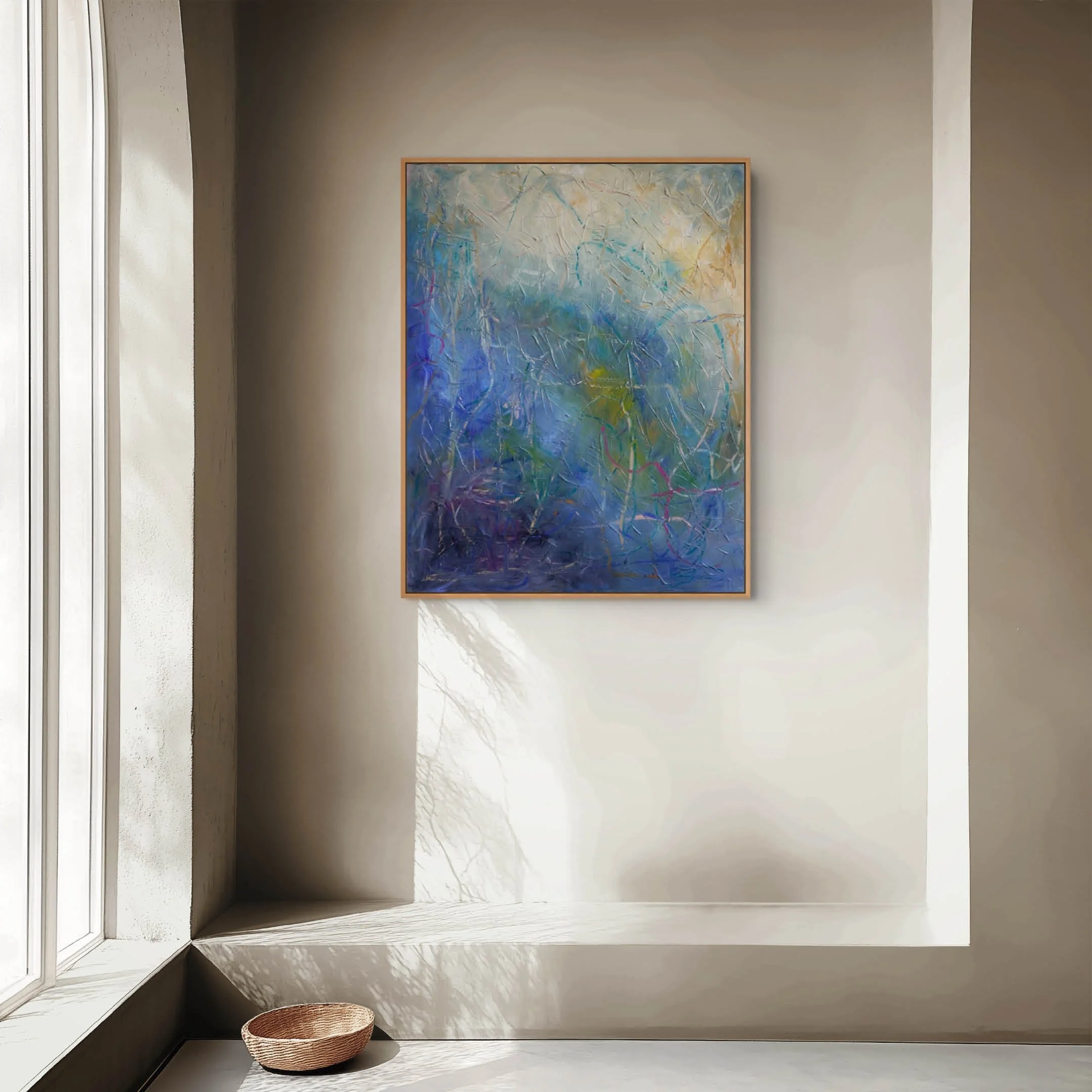 Contemporary room with a large abstract painting on the wall. Sunlight streams through a window, casting shadows on the floor. A woven basket is placed on the floor near the window.