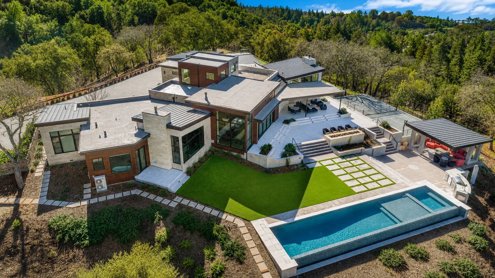 Aerial view of Gumtree in Los Gatos, featuring the modern custom residence, large pool, outdoor living areas, manicured lawn, and mature tree canopy.