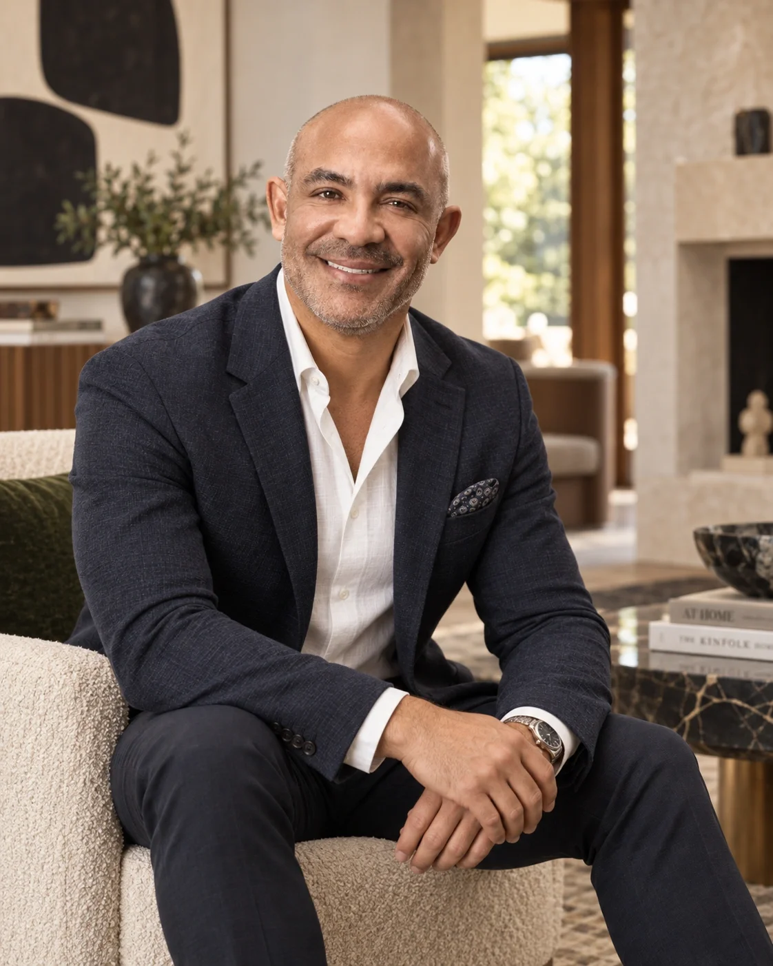 Steve Massei, founder of Massei Construction, seated in a modern residential interior wearing a dark blazer and white shirt.
