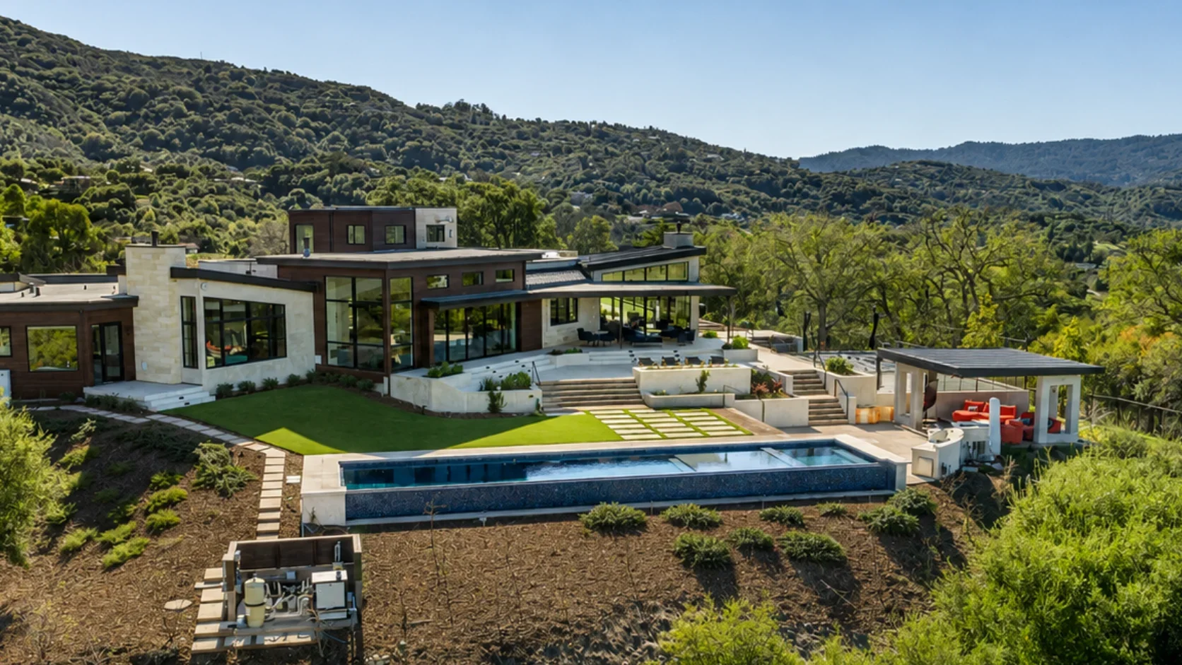 Rear exterior of Gumtree in Los Gatos, featuring expansive glazing, outdoor living areas, a swimming pool, and hillside views surrounded by mature trees.