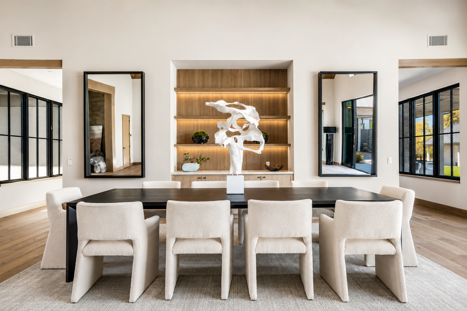 Dining room at Trubody Ranch in Napa Valley featuring a dark dining table, upholstered seating, custom wood shelving, black-framed architectural details, and natural light.