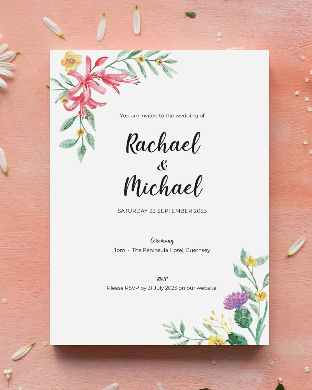 A wedding invitation card with floral watercolor decorations in the top left and bottom right corners, placed on a pink surface with scattered flower petals.