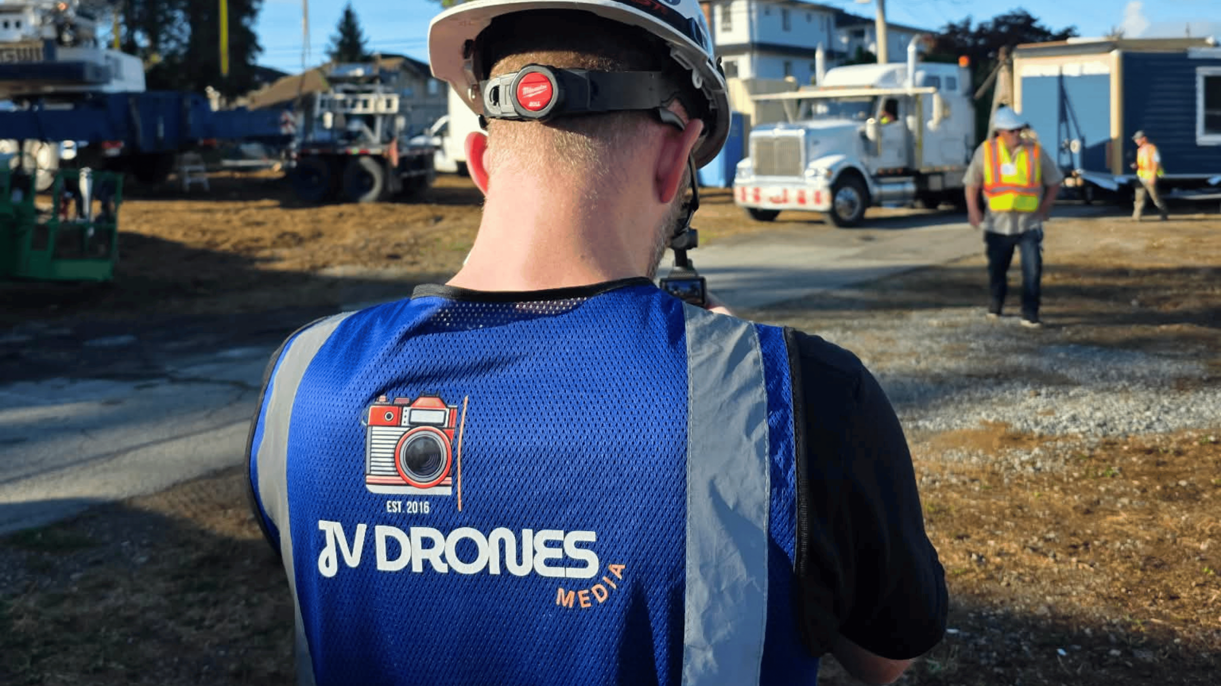 JV Drones media production crew member filming on an active commercial construction site along side the Mayor of Burnaby and Mayor of Penticton.