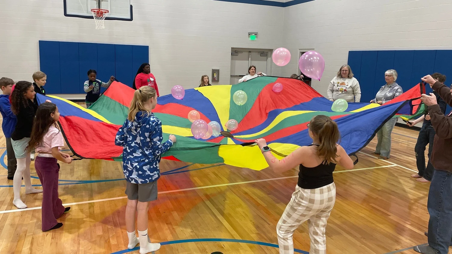 Children playing with a parachute in the gym