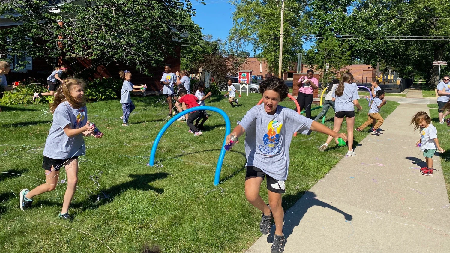 Kids running an obstacle course on the lawn at camp