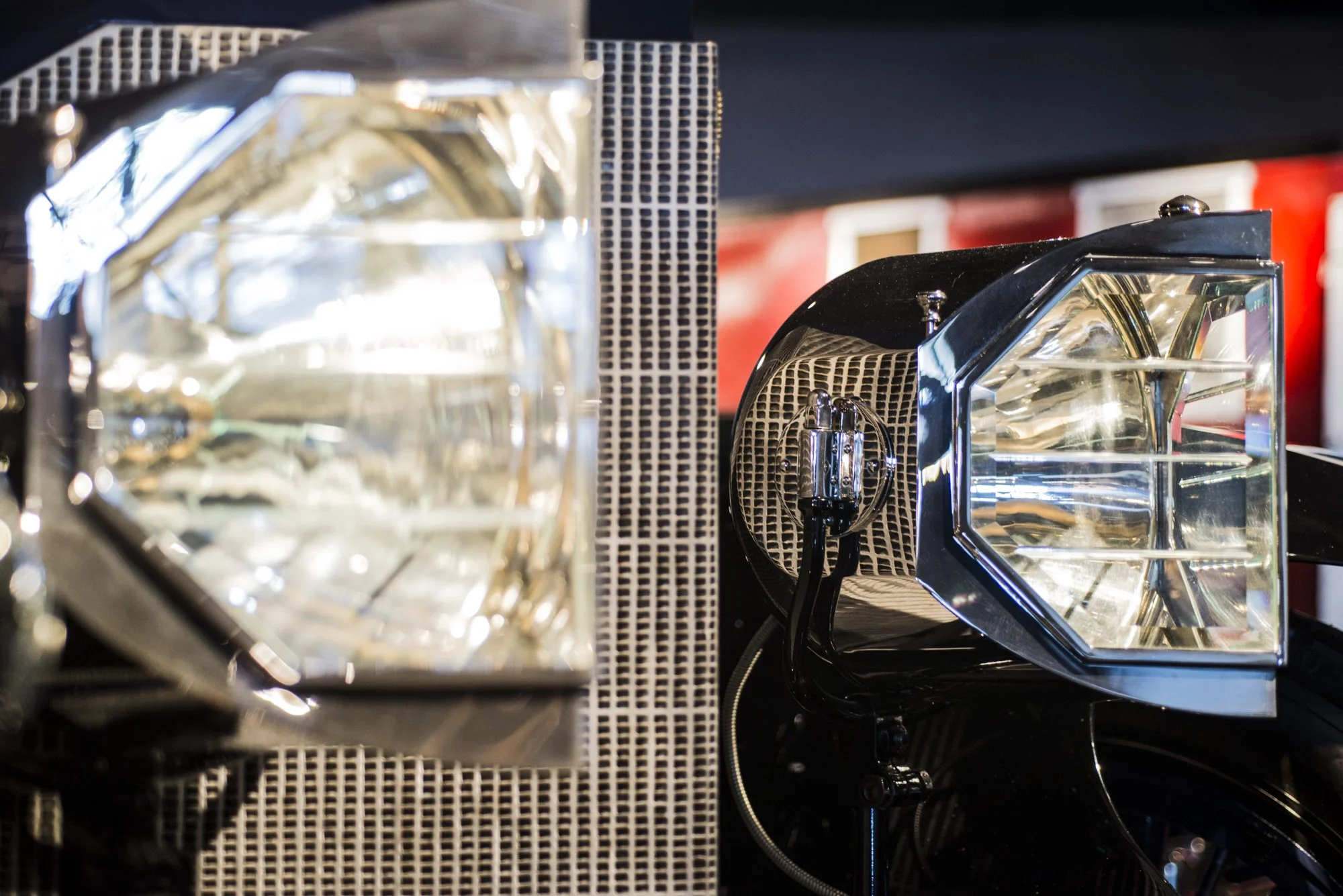 Close-up of two car headlights with reflective surfaces and black grill outlines.