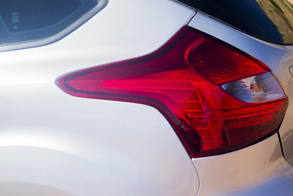 Close-up of the rear right tail light of a silver sedan car.