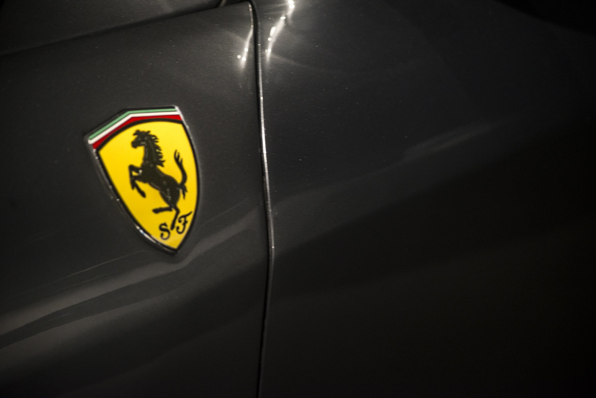 Close-up of a black Ferrari car with the Ferrari logo visible on the side.
