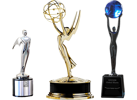 Three awards or trophies on a stand, including an Emmy trophy, a Global Shorts trophy, and a Telly.