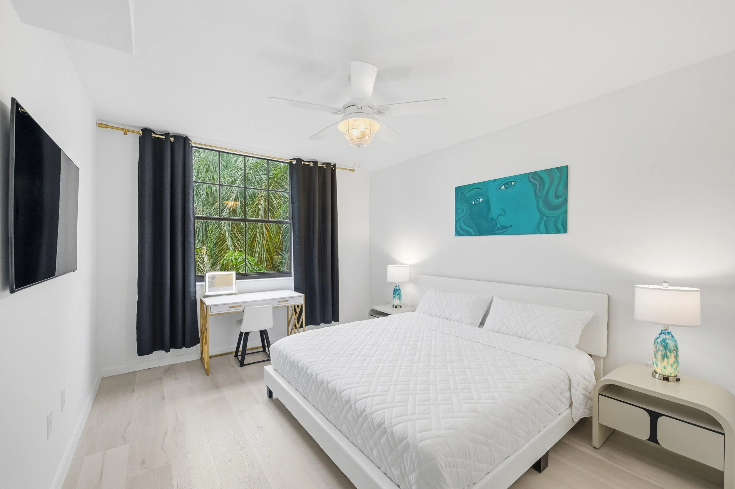 Bright bedroom with white furnishings and black accents.