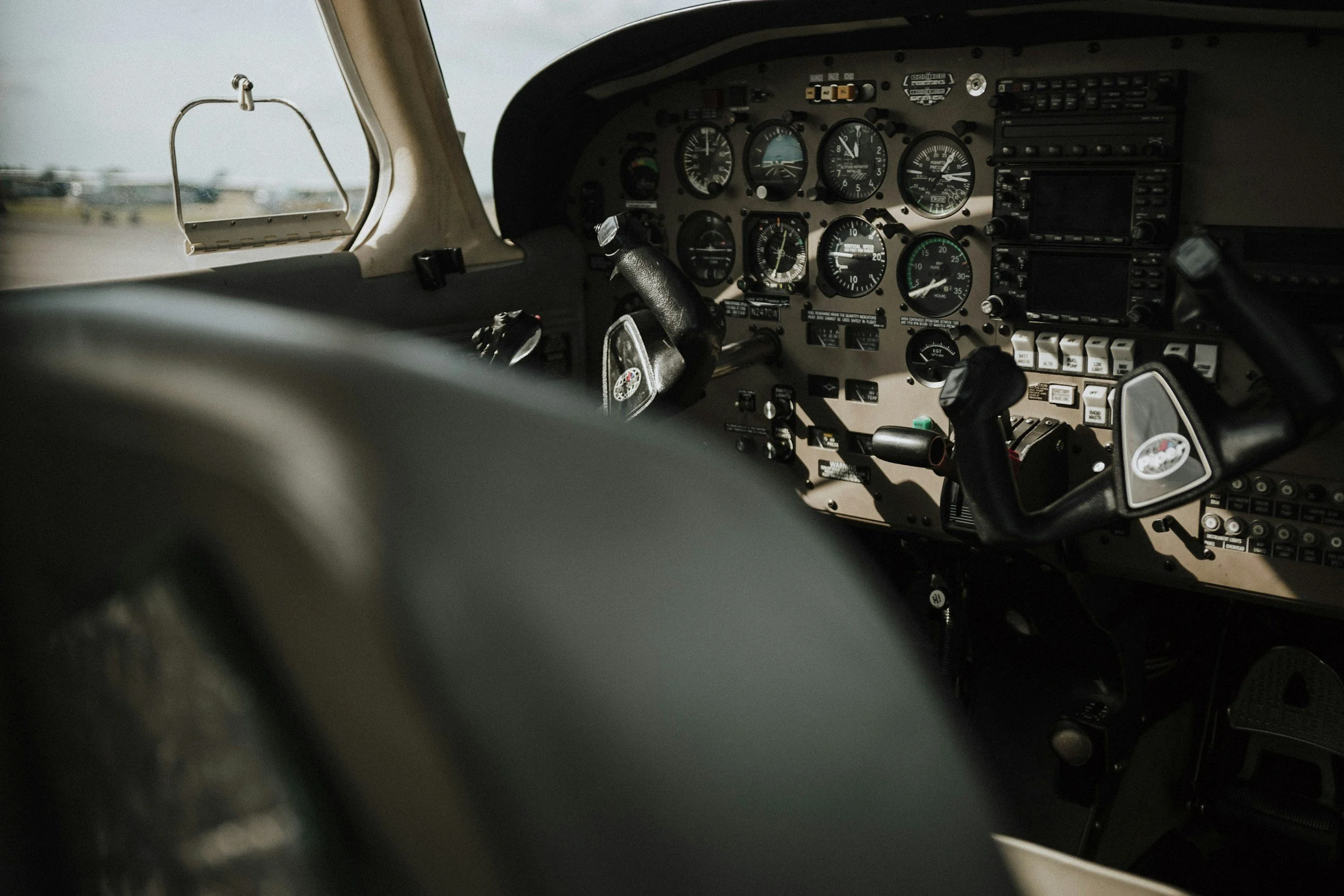 Cockpit view of a small airplane's instrument panel with various gauges and controls.