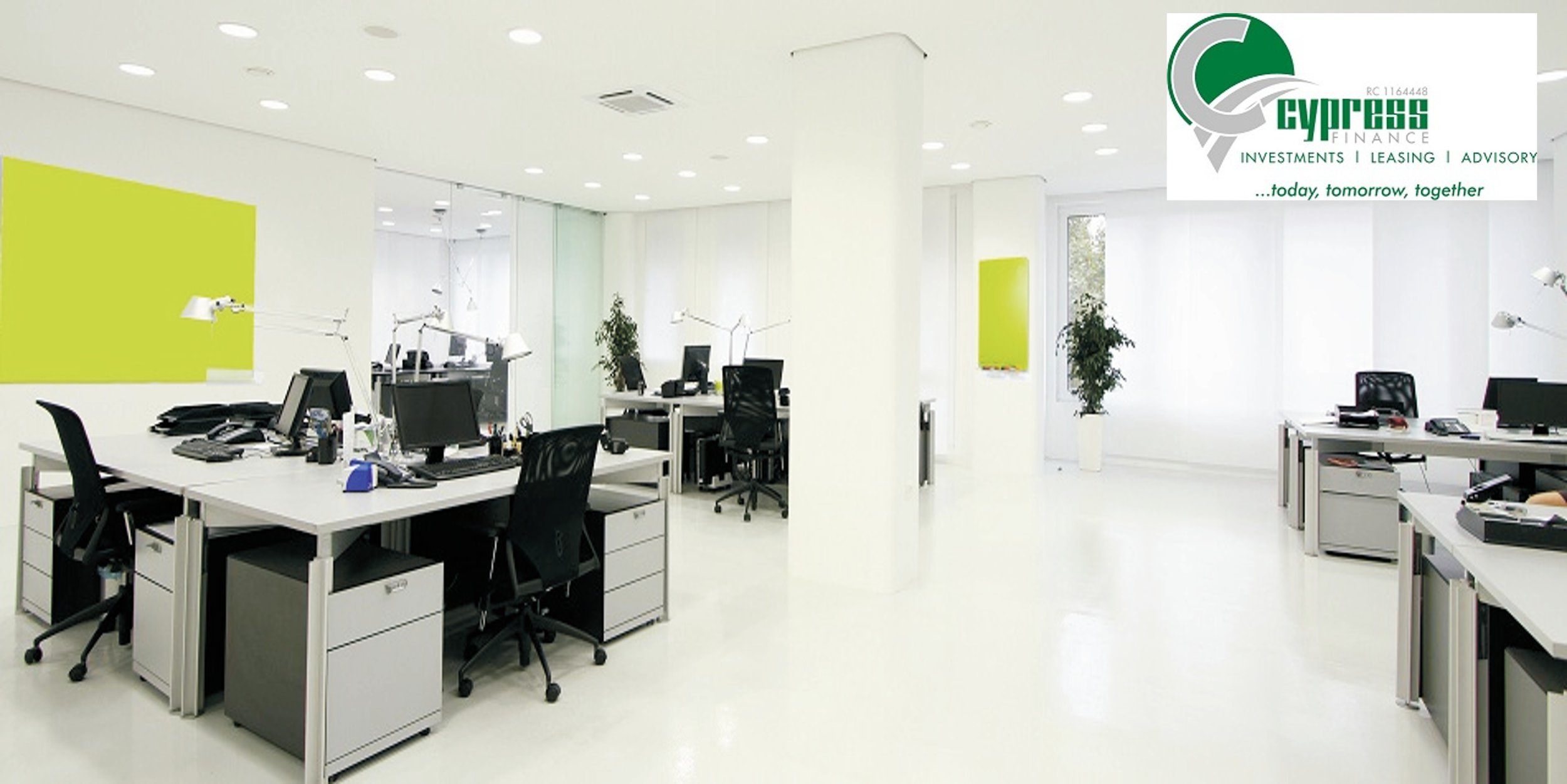 Empty modern office with white desks, black chairs, computers, and green plants. There is a logo in the upper right corner for Cypress Finance.