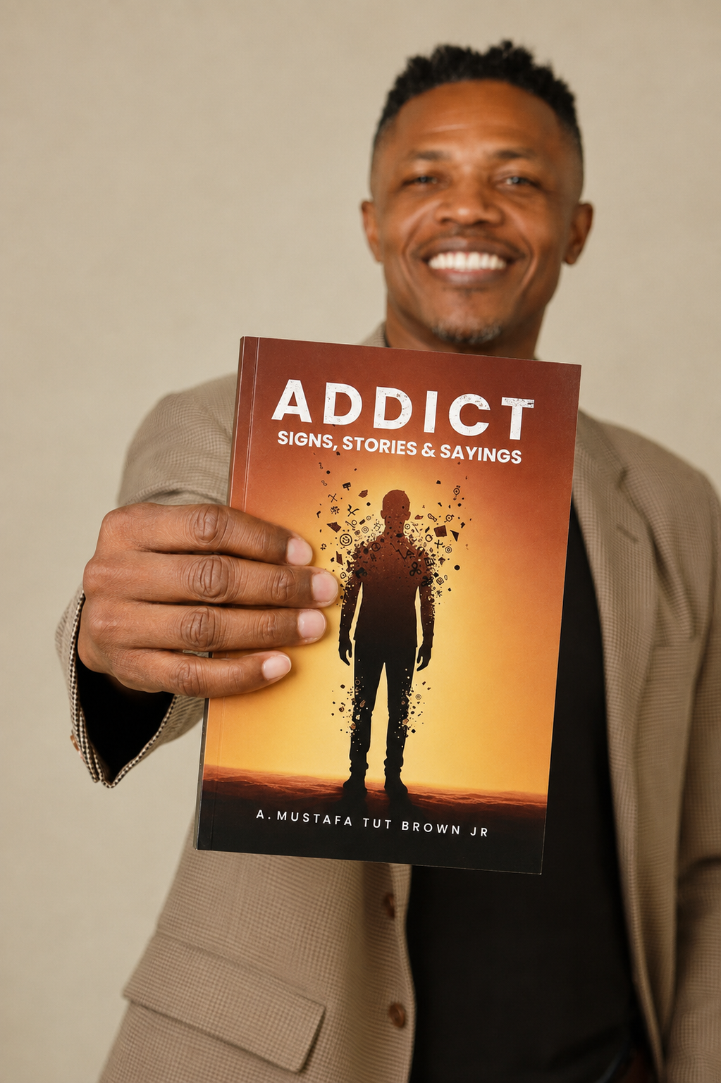 A. Mustafa Tut Brown Jr. holding ADDICT: Signs, Stories & Sayings.