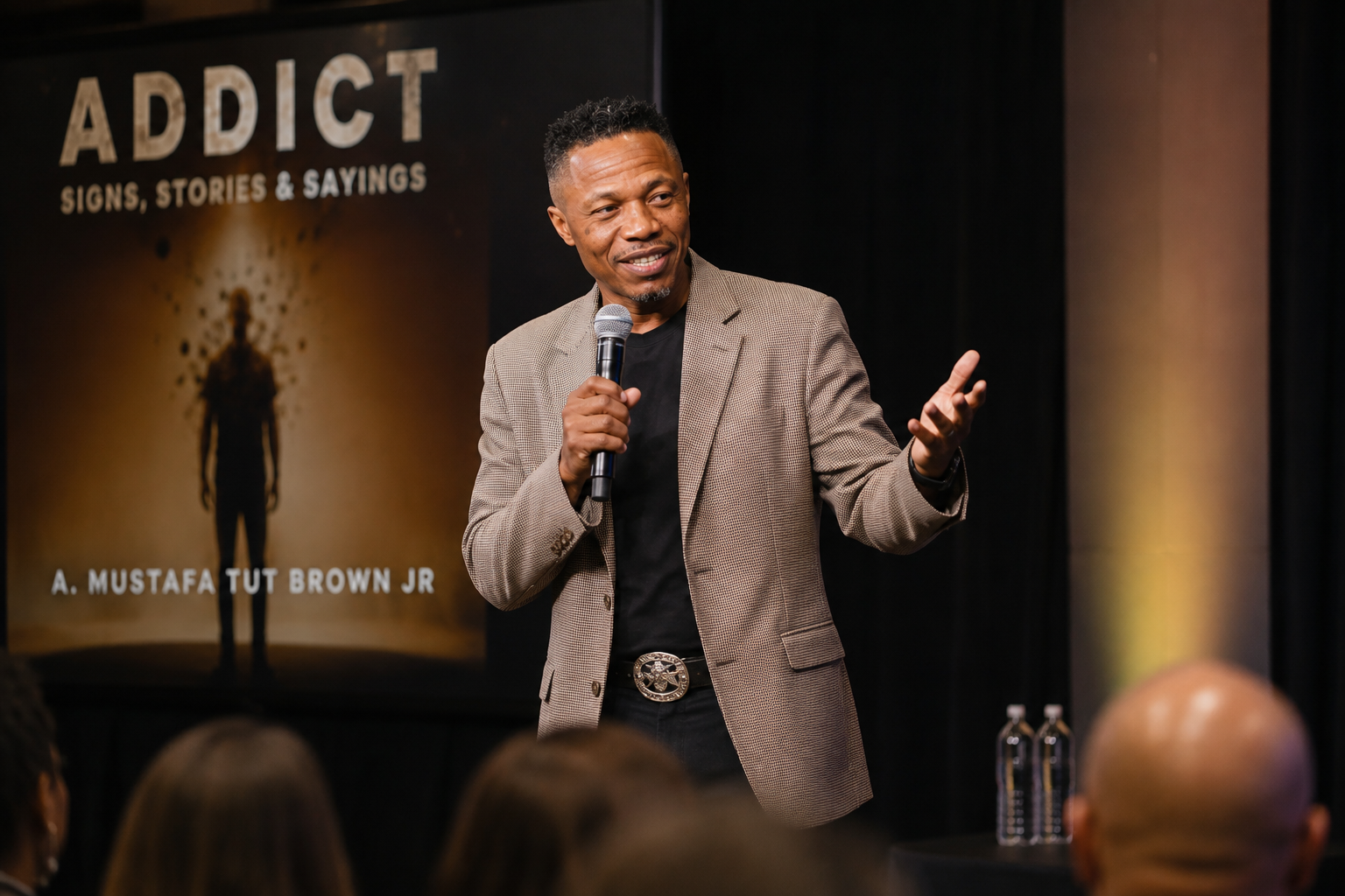 Author and speaker A. Mustafa Tut Brown Jr. speaking on stage about ADDICT: Signs, Stories & Sayings.