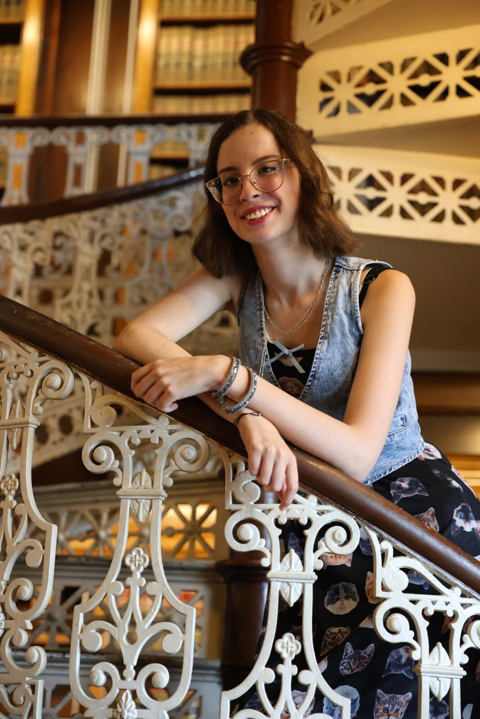 Senior portrait beside an ornate library railing.