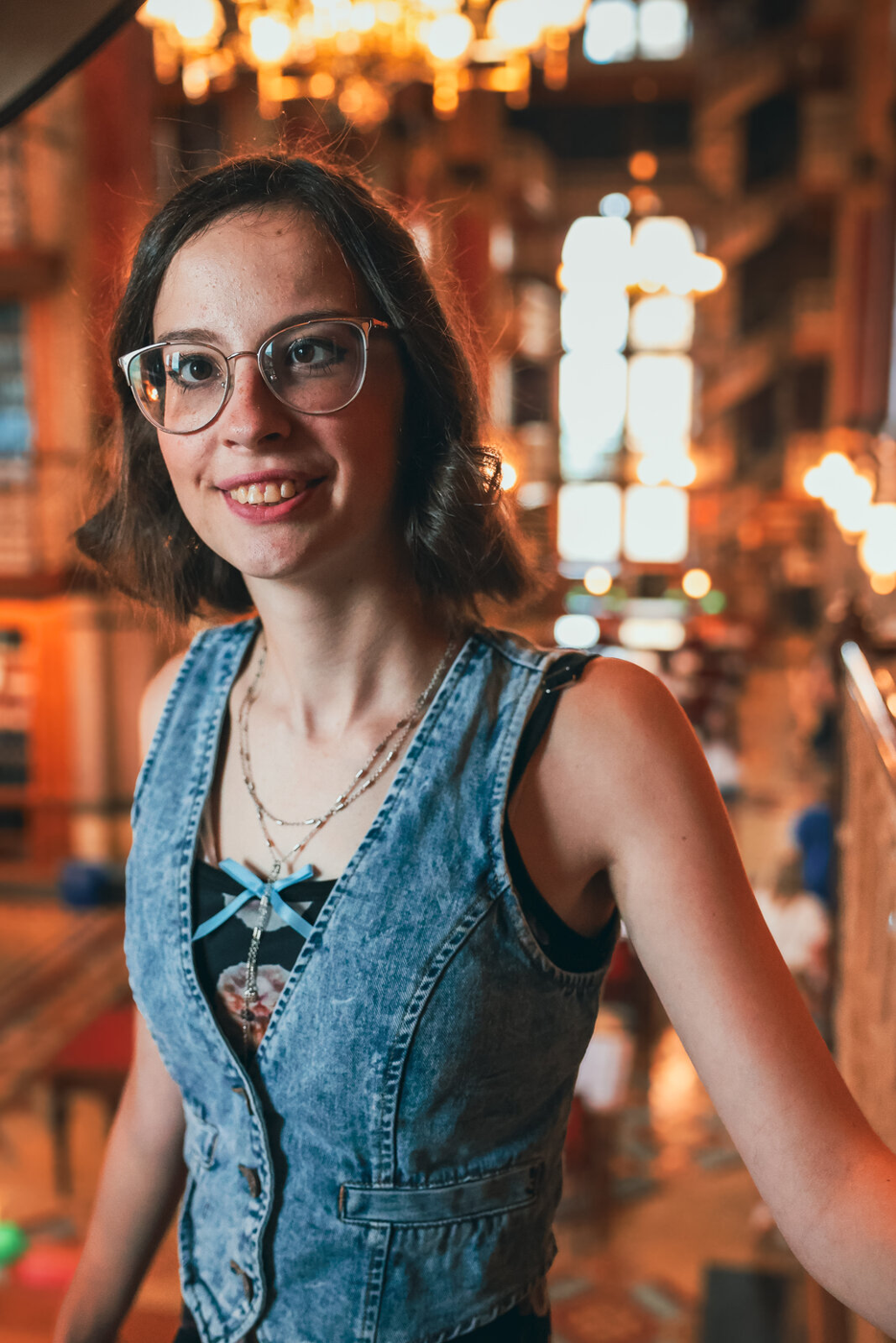 Senior portrait in a library with warm lighting.