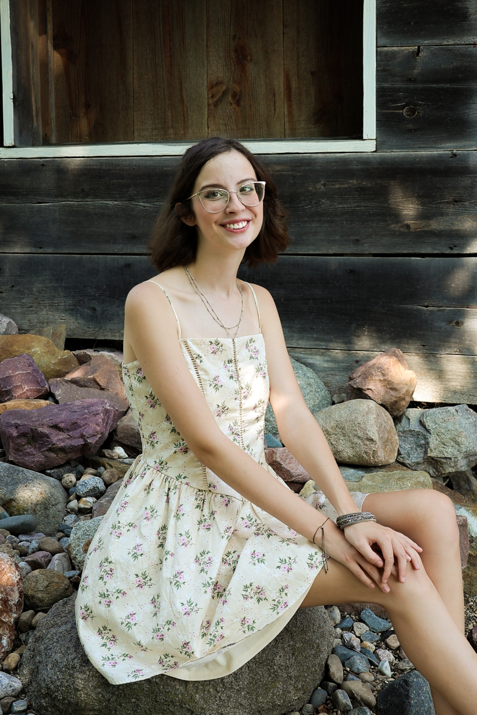 Senior portrait in a floral dress on rocks.