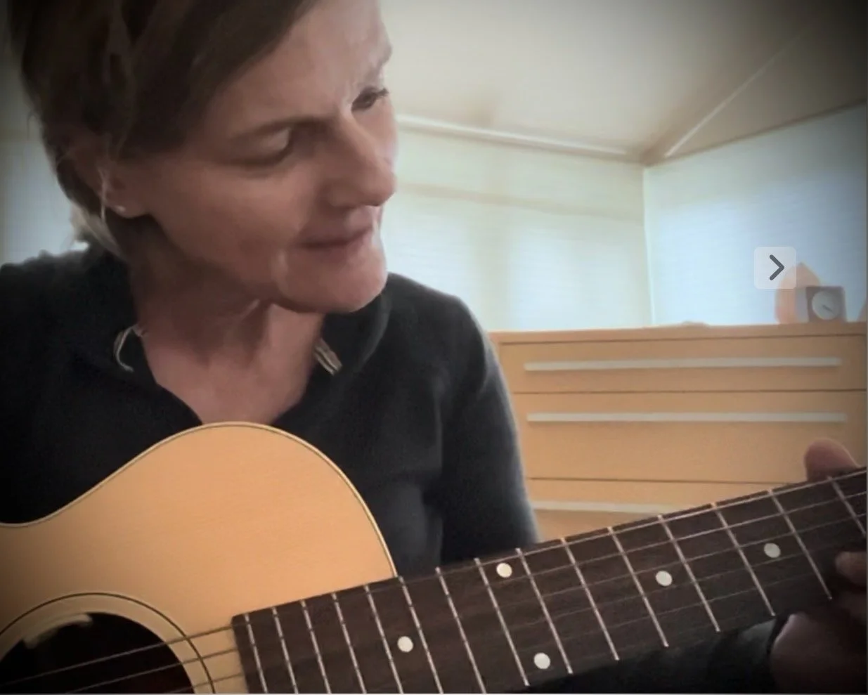 Close-up of Marla Beck playing guitar.