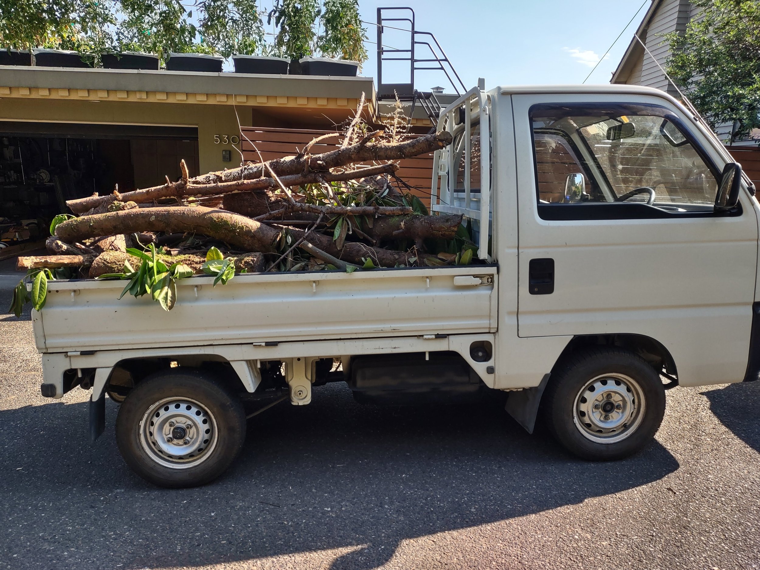 A 1994 Honda Acty with a full load of wood in the back.