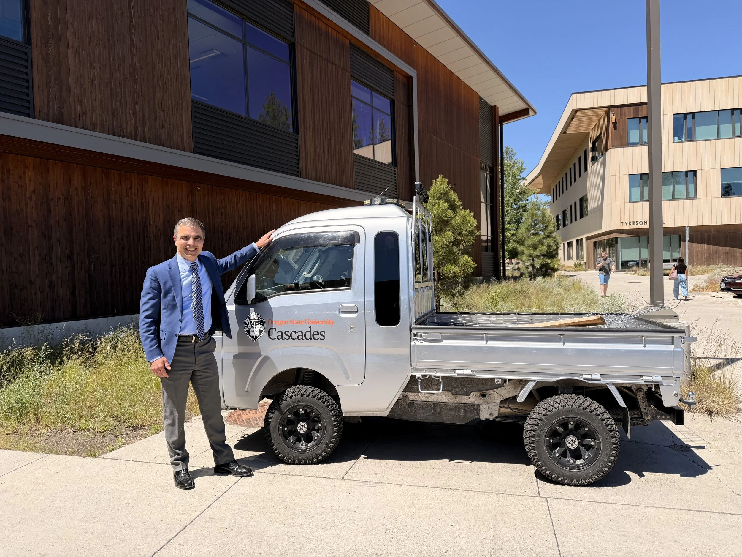 Senator Anthony Broadman next to a kei truck owned by OSU Cascades campus..