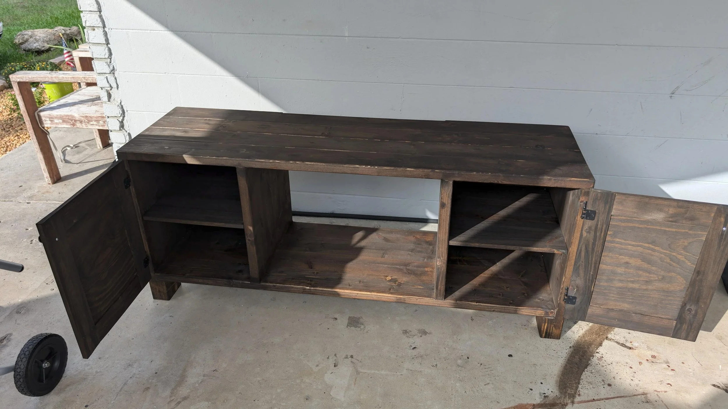 Wooden TV stand with open shelves and closed storage.