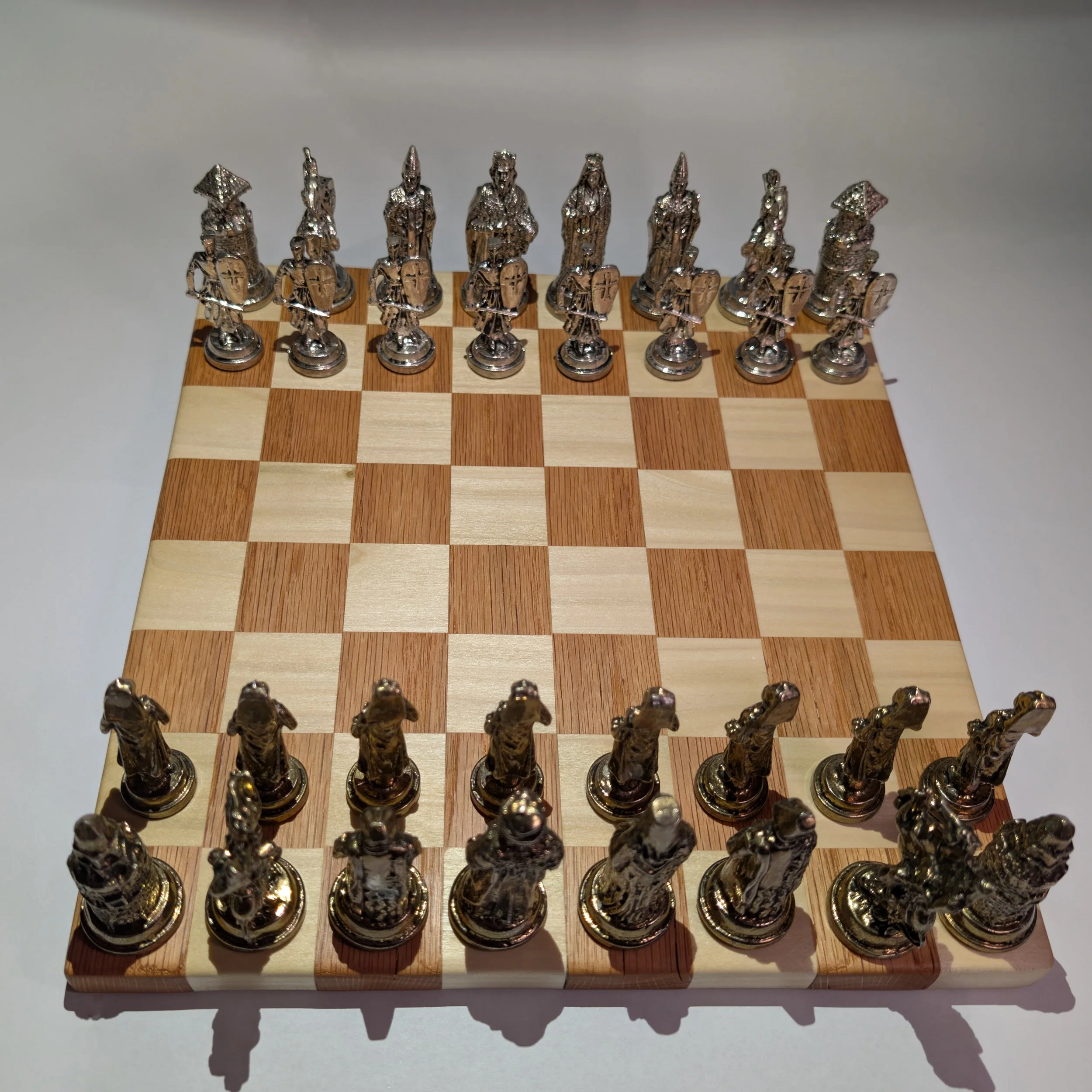 A chessboard with metallic chess pieces arranged in starting positions