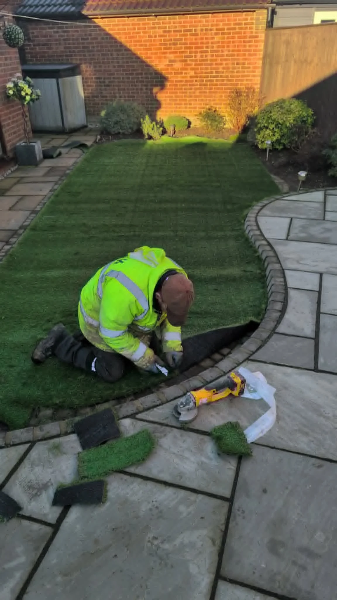 Landscaper installing artificial grass in a garden