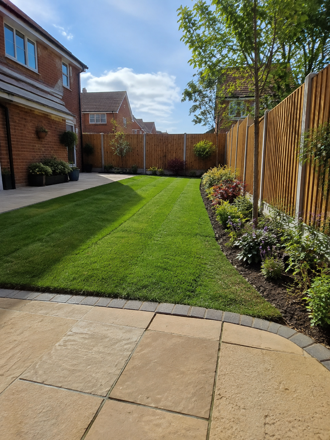 Finished landscaped garden with lawn, paving and flower borders