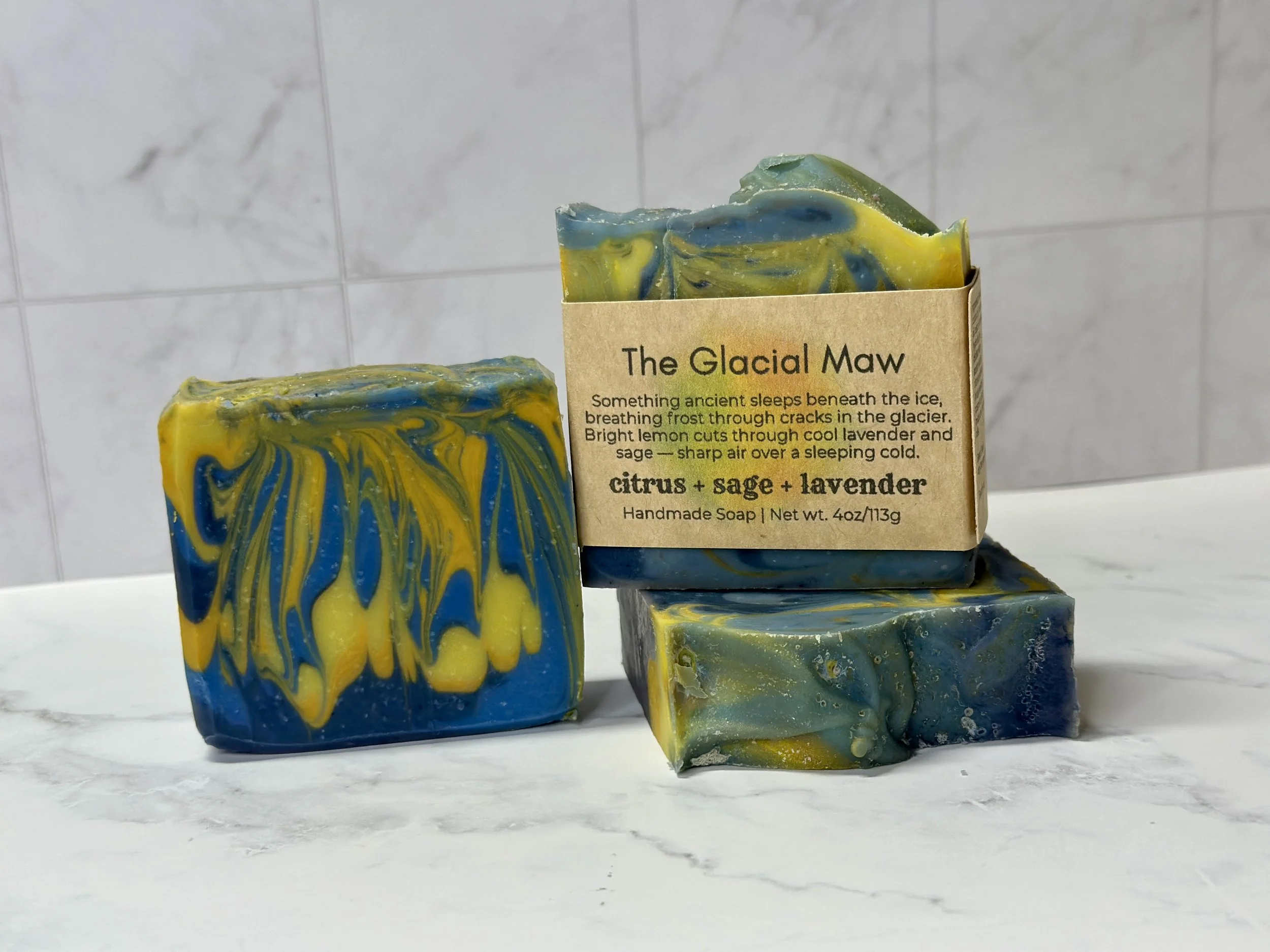 Photo of handcrafted artisan soaps, posed to appeal. The soaps are made of deep blue and bright yellow swirls.