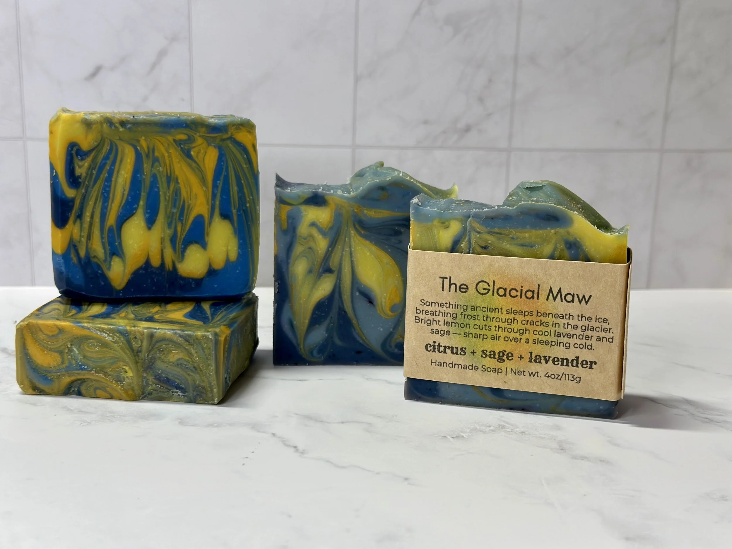 Photo of handcrafted artisan soaps, posed to appeal. The soaps are made of deep blue and bright yellow swirls.