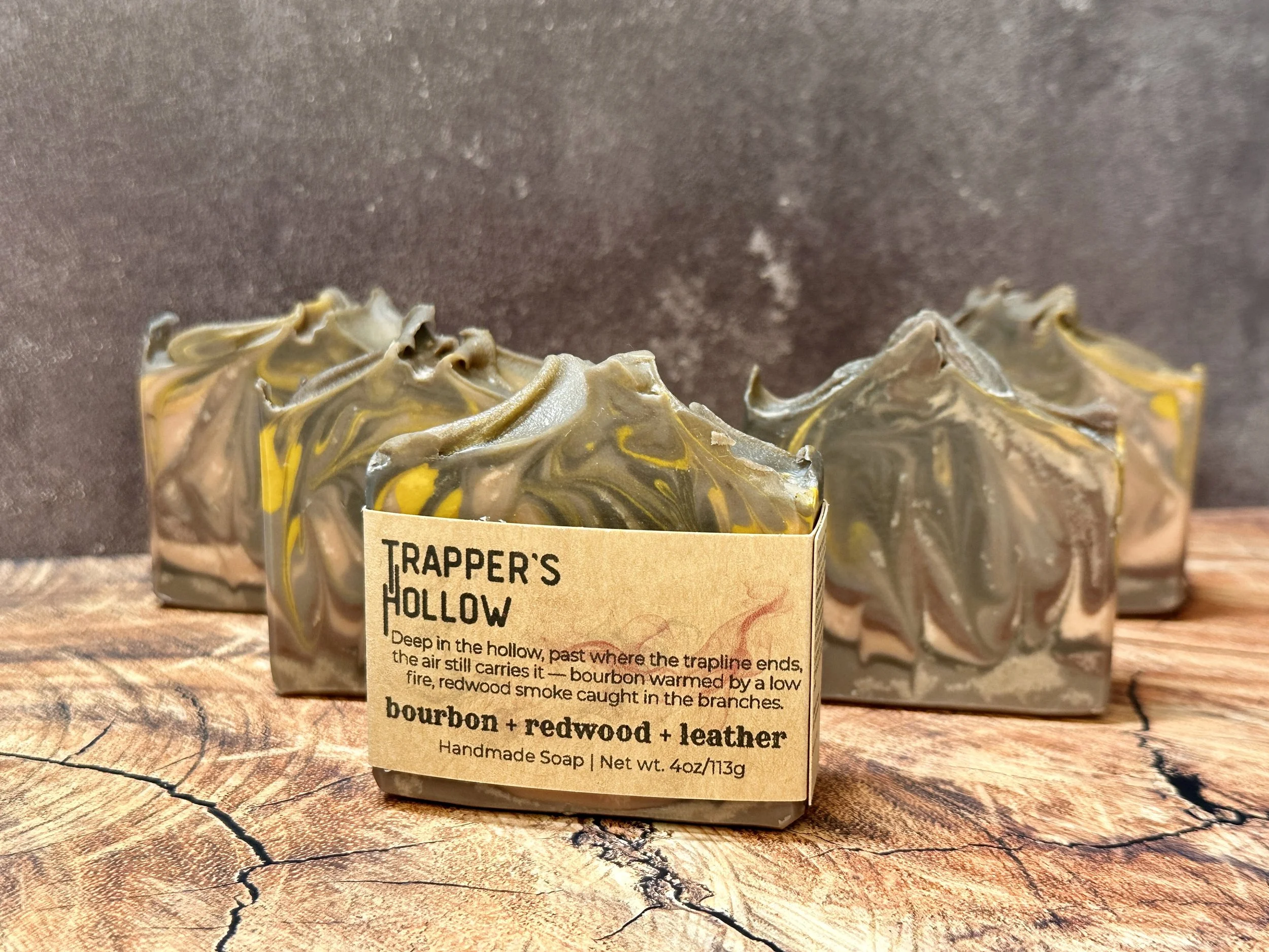 Photo of handcrafted artisan soaps, posed to appeal. The soaps made of swirls of brown, with additions of yellow and peach.