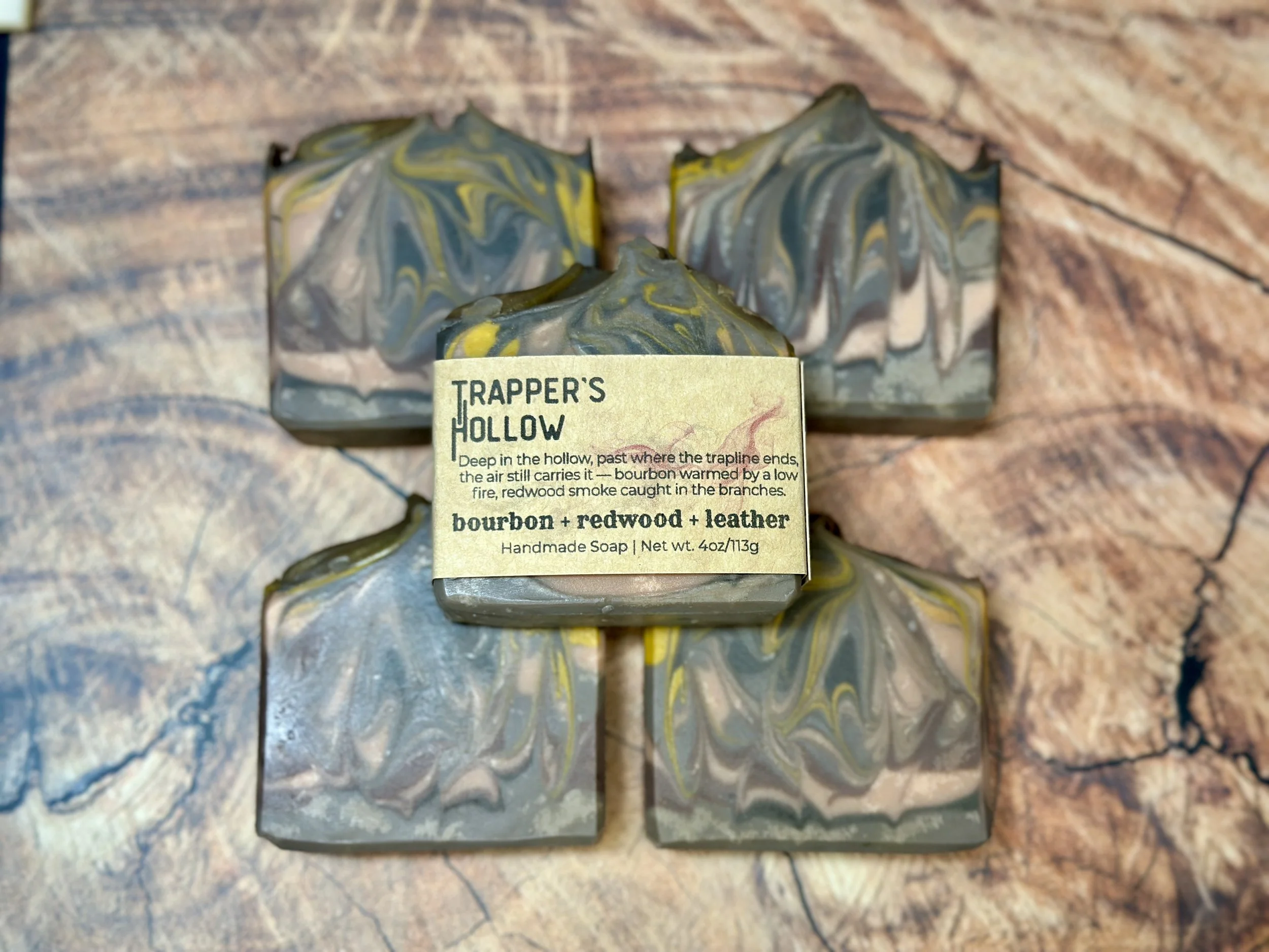 Photo of handcrafted artisan soaps, posed to appeal. The soaps made of swirls of brown, with additions of yellow and peach.