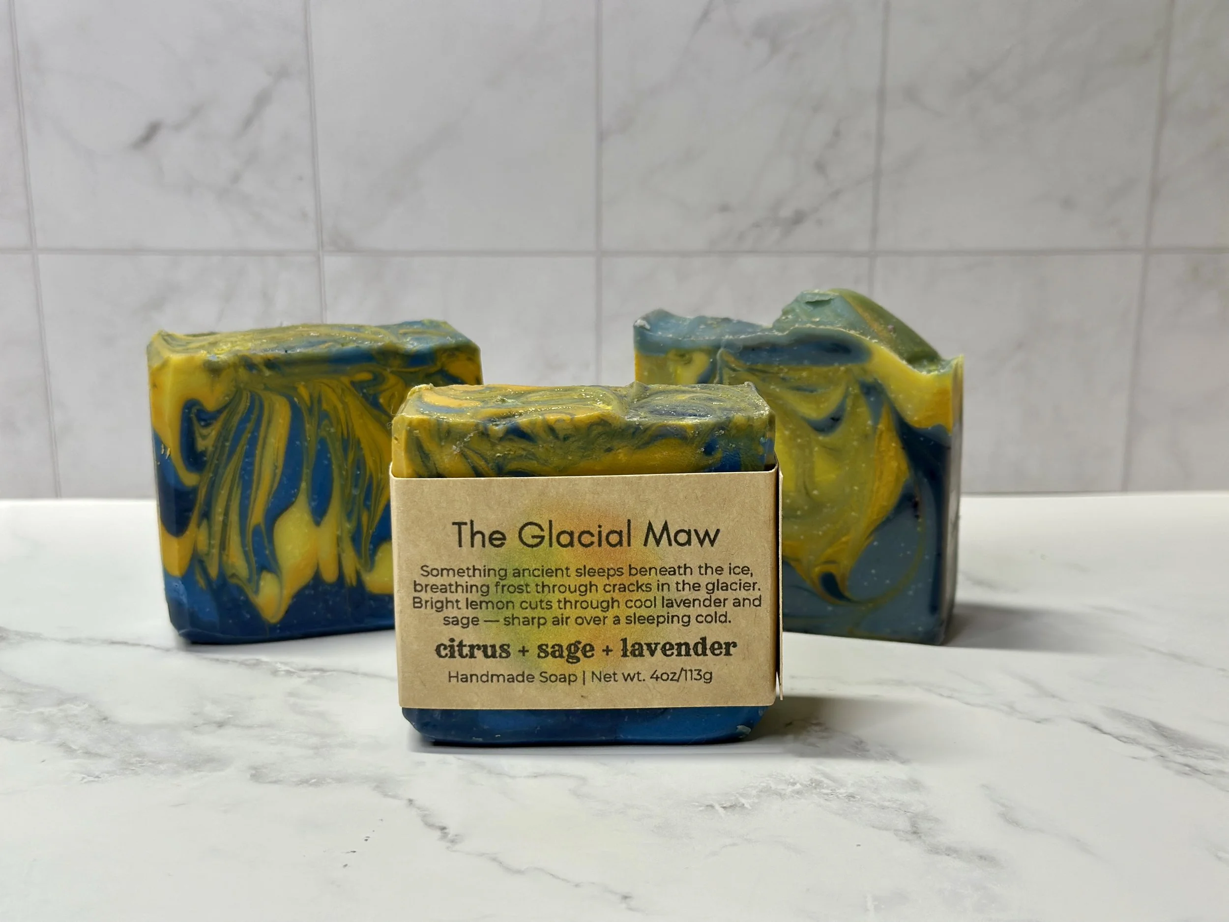 Photo of handcrafted artisan soaps, posed to appeal. The soaps are made of deep blue and bright yellow swirls.