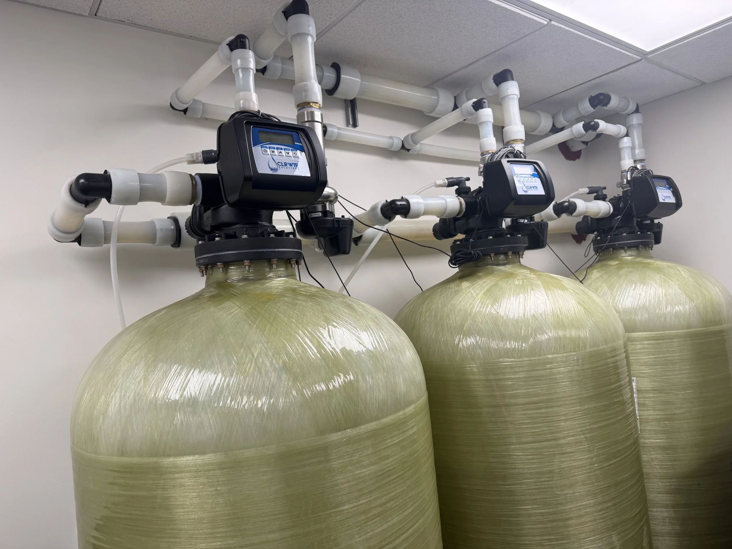 Close-up of the tops of three CLR WTR branded commercial water filters