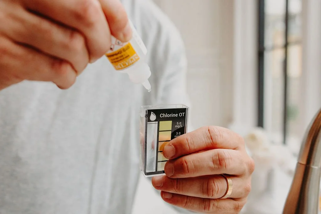 Technician placing a drop of water into a water test kit during a water quality test