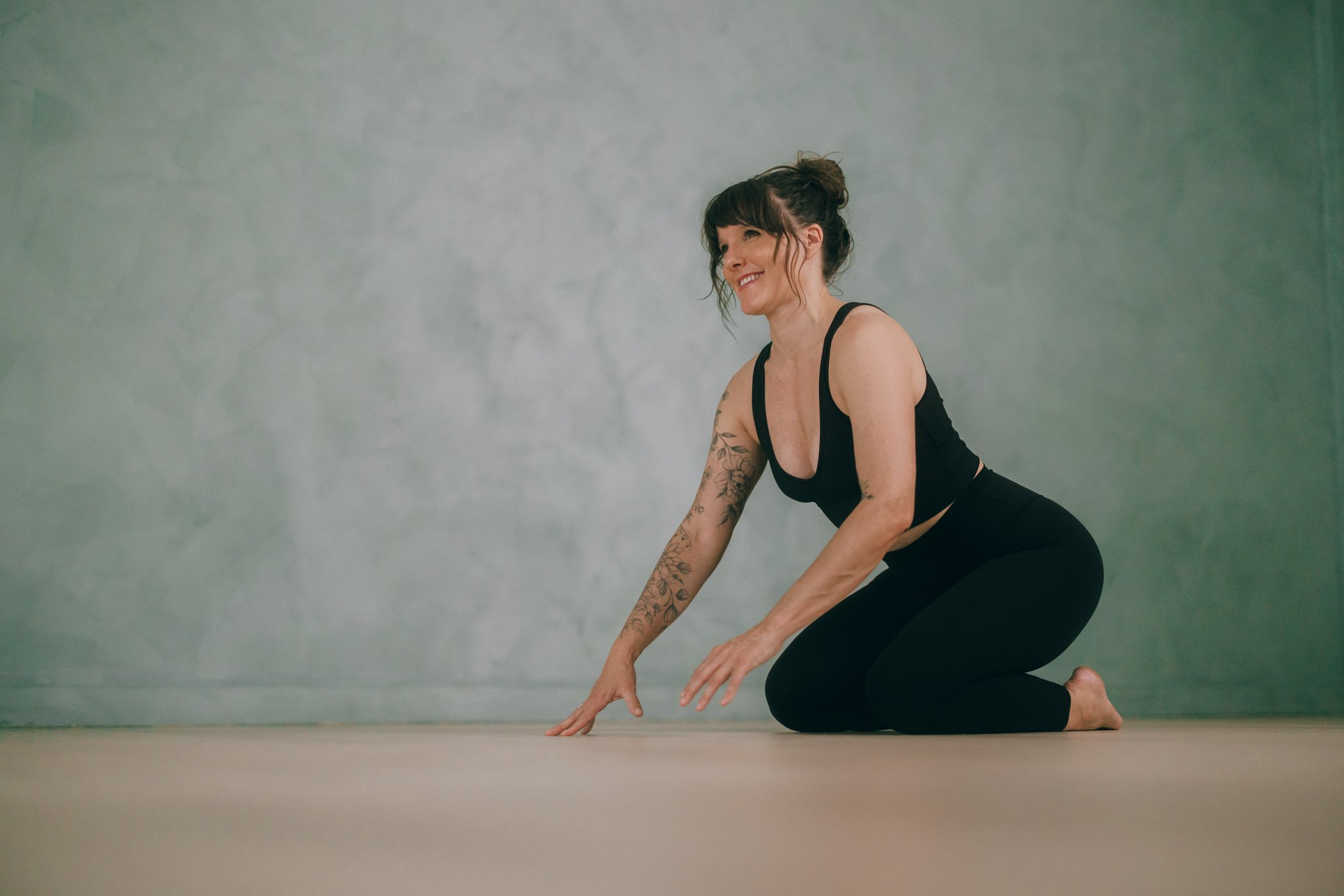A woman practicing yoga in a kneeling position on the floor