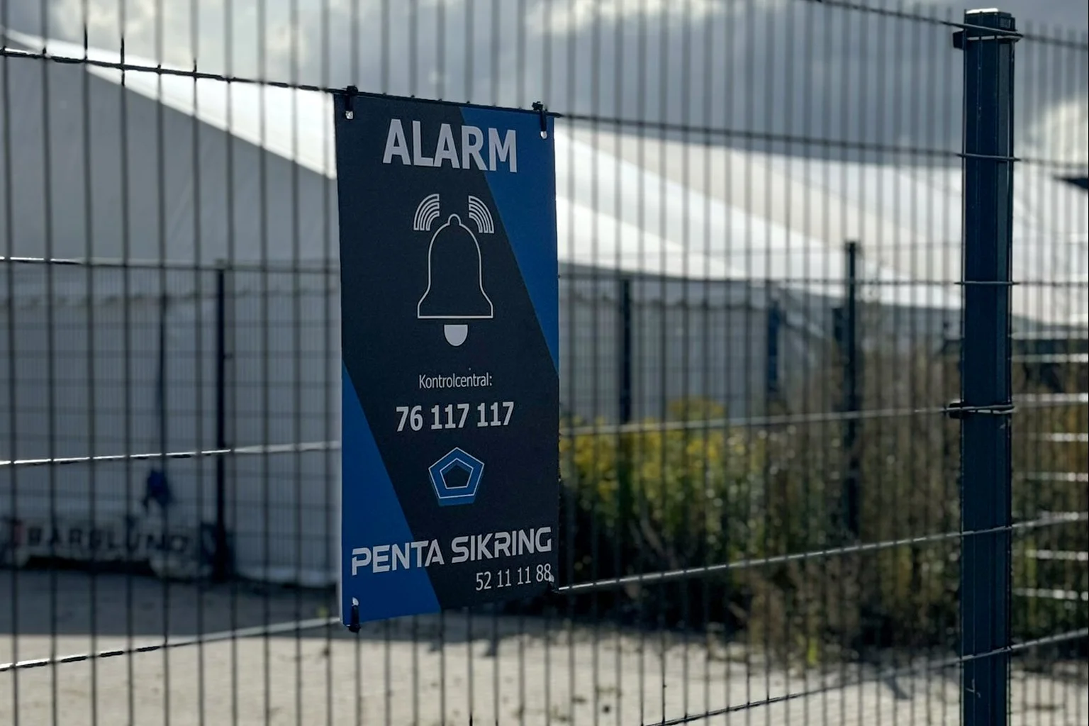 Trådhegn med advarselsskilt om alarm og kontaktinformation til PENTA SIKRING.