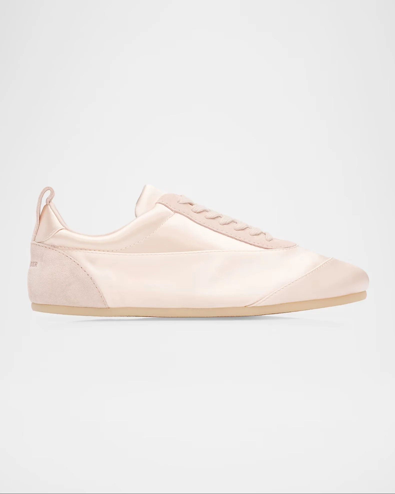 A light pink minimalist sneaker with a smooth synthetic upper, with laces and a rounded toe, set against a plain light background.
