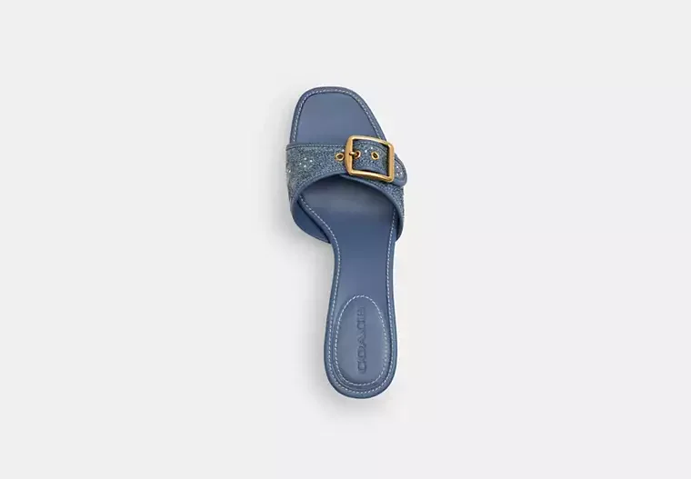A single blue slide sandal with a buckle strap and a glittery band on a white background.