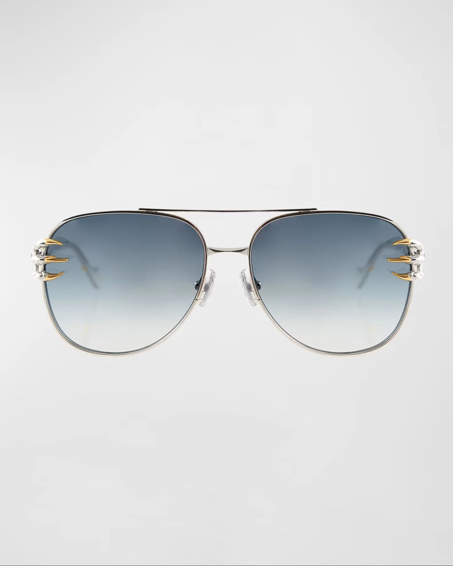 Pair of sunglasses with a metallic frame, dark tinted lenses, and decorative gold accents on the temples, shown against a light gray background.