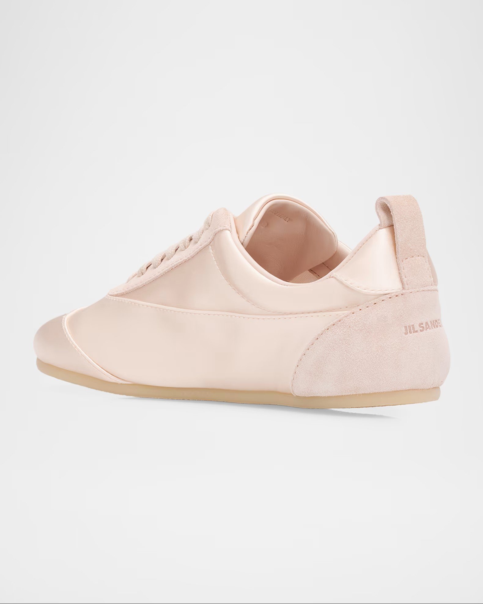 A light pink sneaker with suede accents and a brand logo on the heel, displayed against a plain white background.