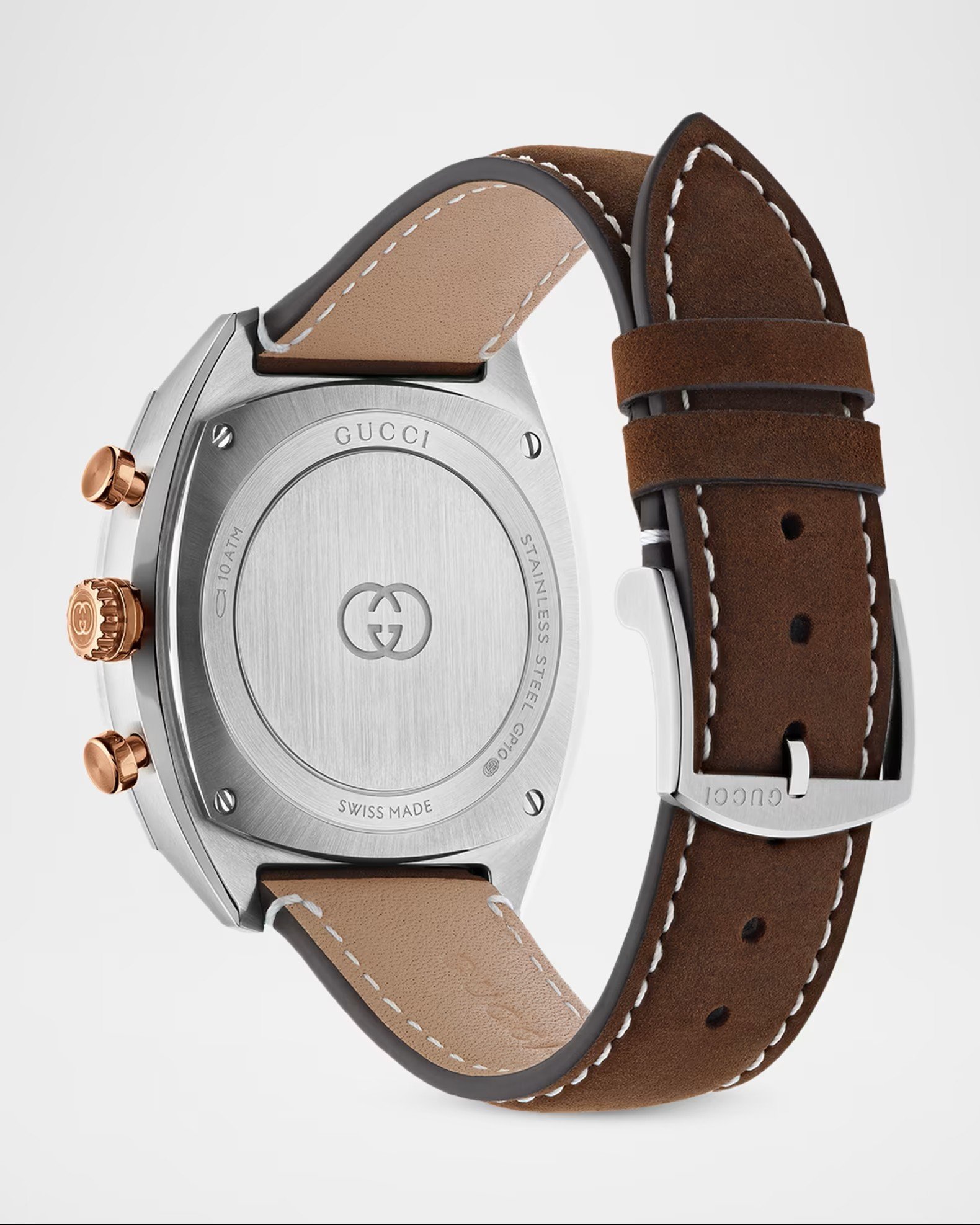 Close-up of a luxury Gucci wristwatch with a stainless steel case, leather strap in dual shades of brown, and rose gold accents.