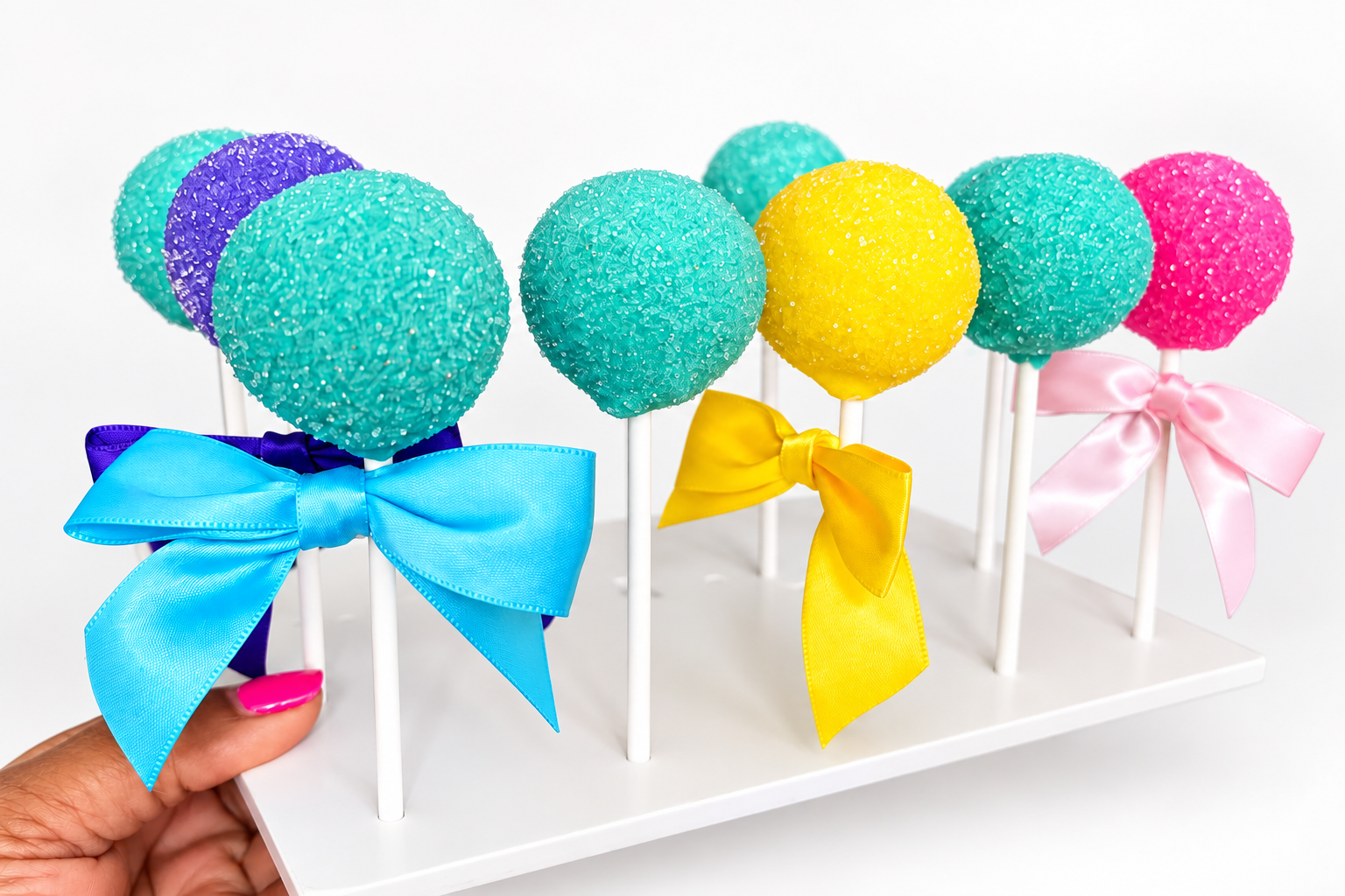 Colorful cake pops with pastel bows.
