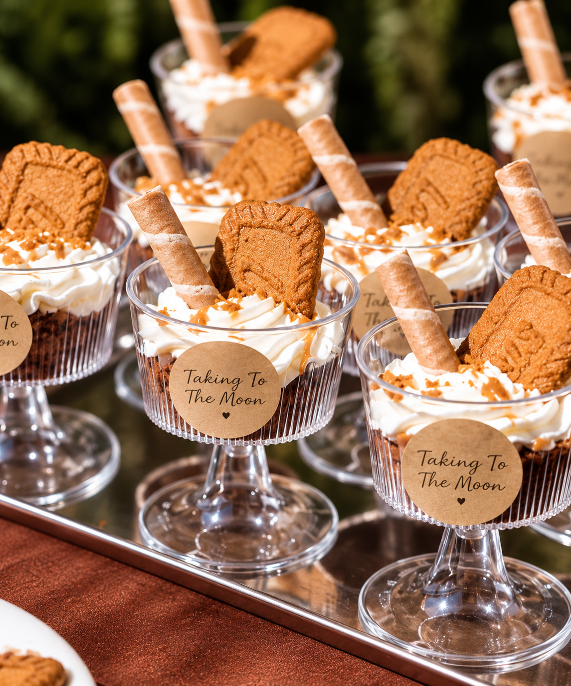 Dessert cups with whipped cream, cookie, and caramel topping, labeled 'Taking To The Moon'
