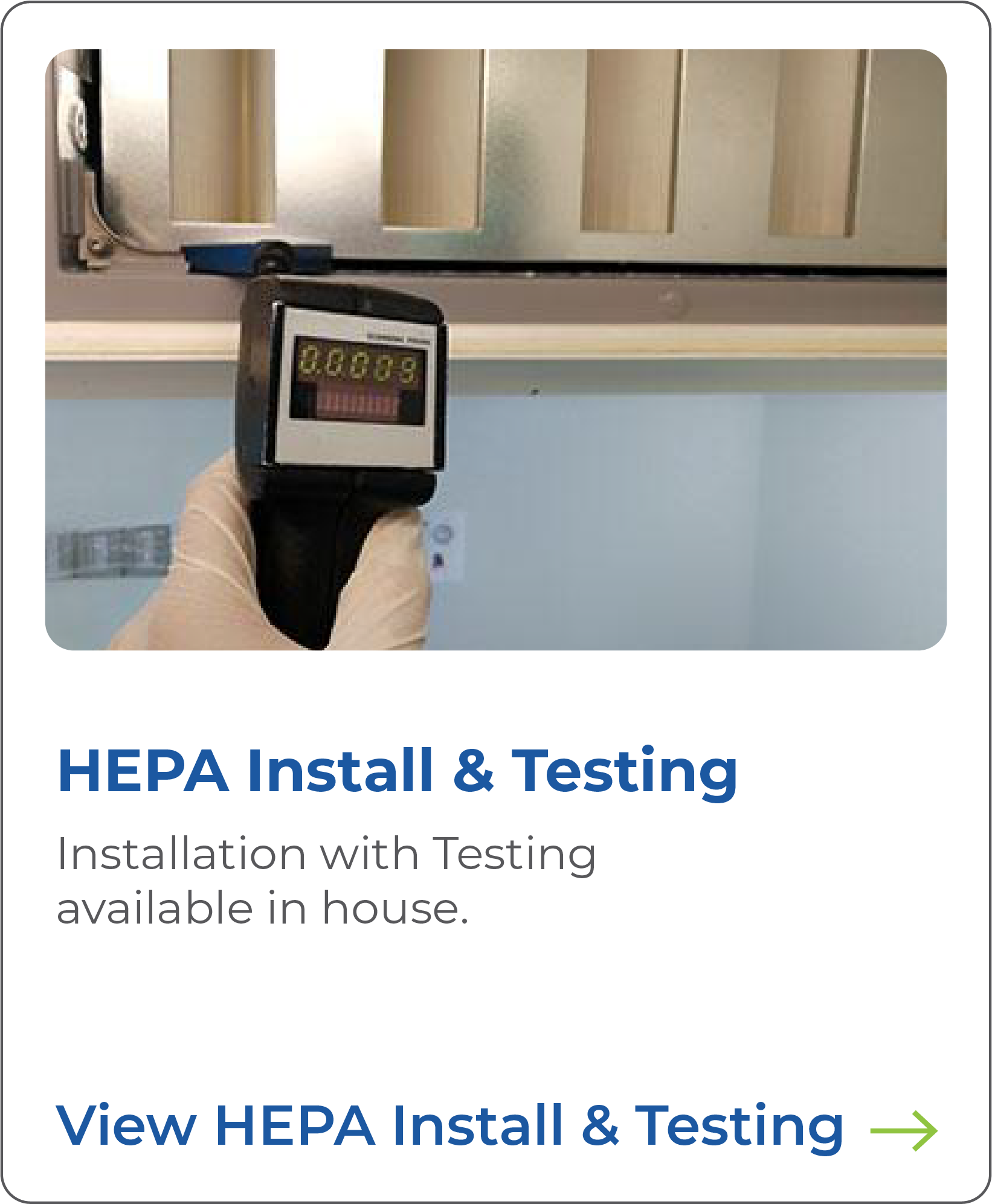 Close-up of a digital moisture meter being held in a person’s gloved hand, measuring humidity on a metallic surface with a background of beige and metallic panels.