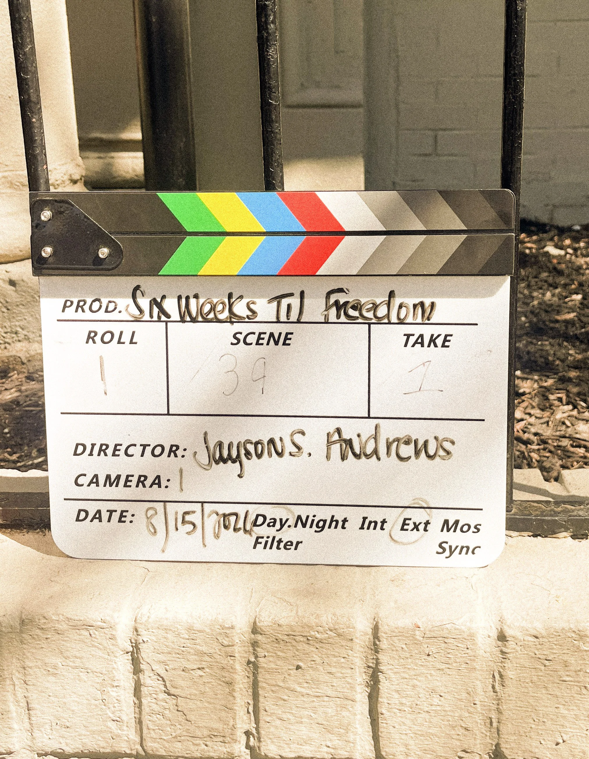 Clapperboard with the title 'Sk Weeks TL Freedom' written on it, placed on a brick wall.