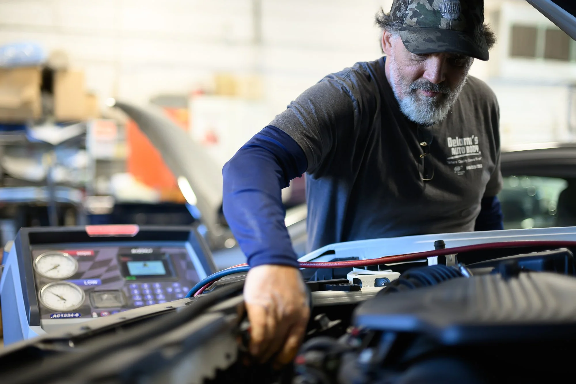 Bruce connecting an air conditioning service machine to a car engine